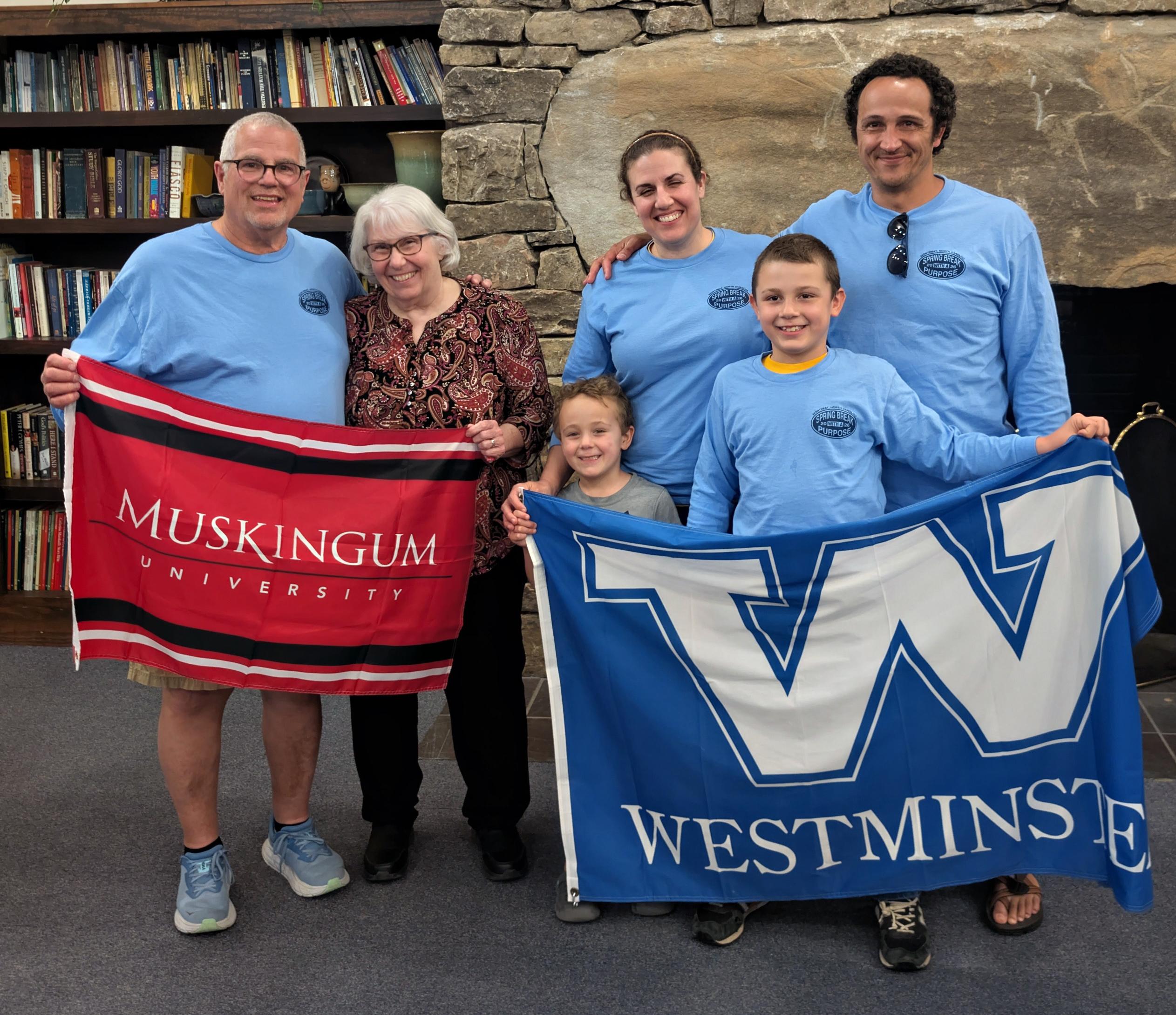 Jim and Jill Mohr, holding the Muskie flag, and their daughter Angie and her husband, along with Jonny and Jacob Urban, are holding the Westminster flag.