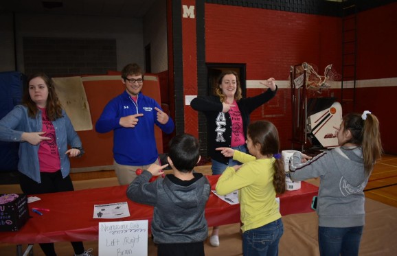 students working with Kids on an activity during the Investigation fair